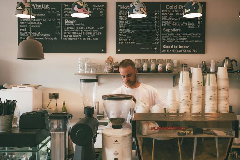 A barista making coffee for their small business.