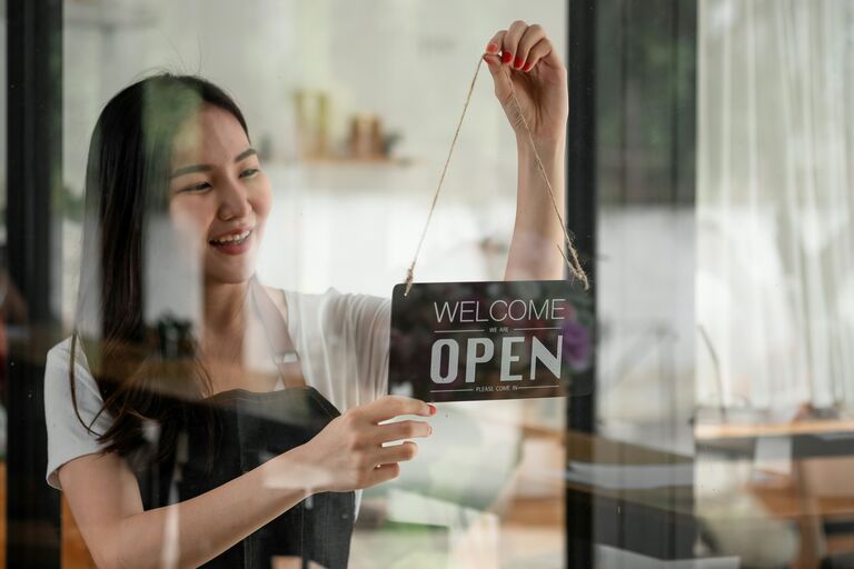 Young woman opening up a store.