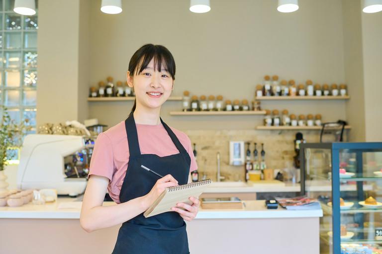 A barista welcoming customers into their small business cafe.